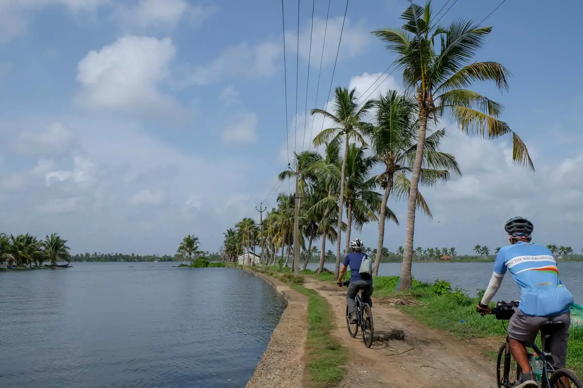 Riding along small canals during a Kochi backwaters bicycle tour