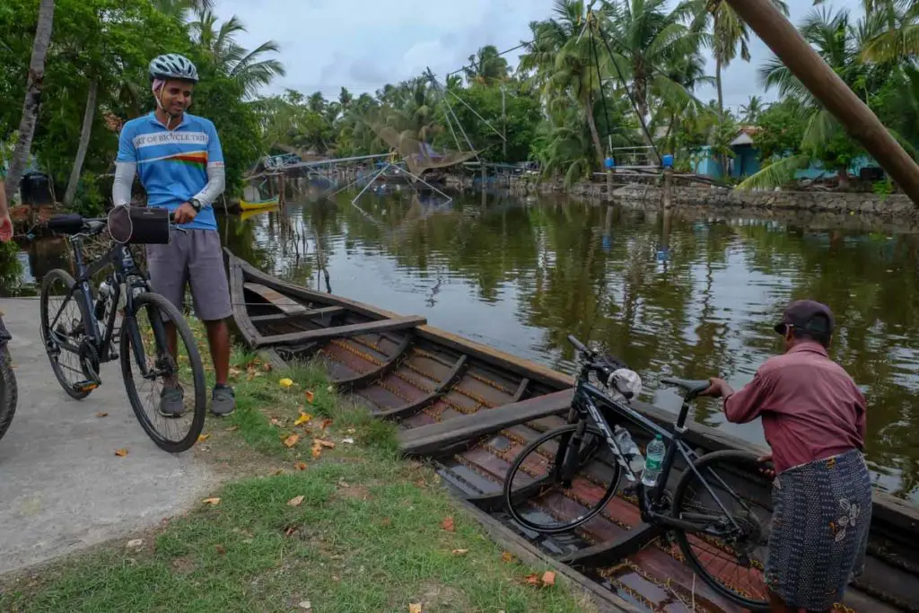 Dibin and the boatmen load our bicycles in a traditional Kerala wooden longboat